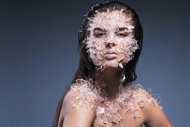 Rostro femenino cubierto con muchos pedazos pequeños de vidrio