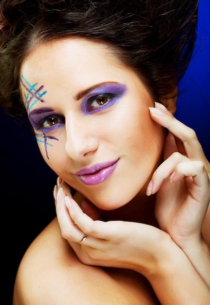 Rostro femenino joven con maquillaje multicolor de moda brillante