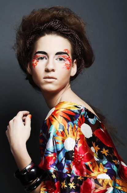 Rostro femenino joven con maquillaje multicolor de moda brillante