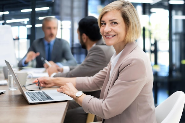 Rostro de hermosa mujer de mediana edad en el fondo de la gente de negocios