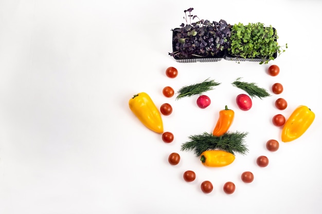 El rostro de un hombre hecho de verduras en rodajas sobre un fondo blanco.