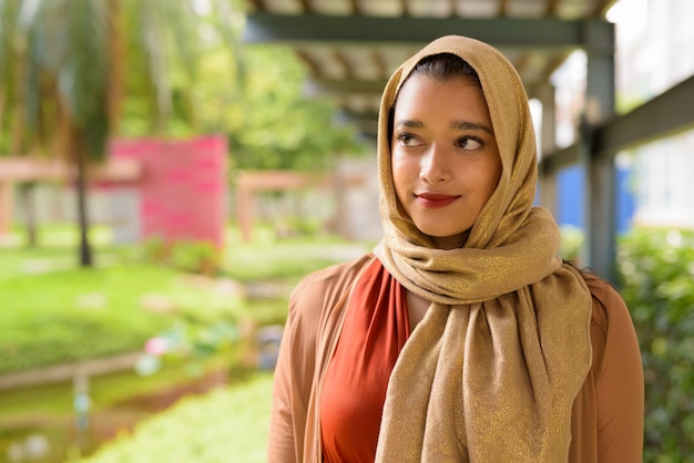 Rostro de joven bella mujer musulmana india pensando en el parque