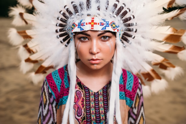 Rostro de joven mujer indígena americana, Cherokee, Navajo. Tocado de plumas de aves silvestres