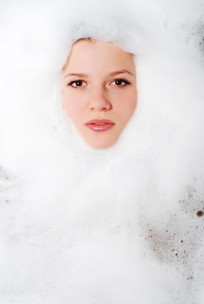 Rostro de una mujer hermosa en espuma blanca