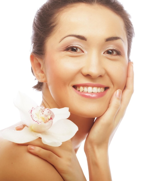 Rostro de mujer hermosa con flor de orquídea