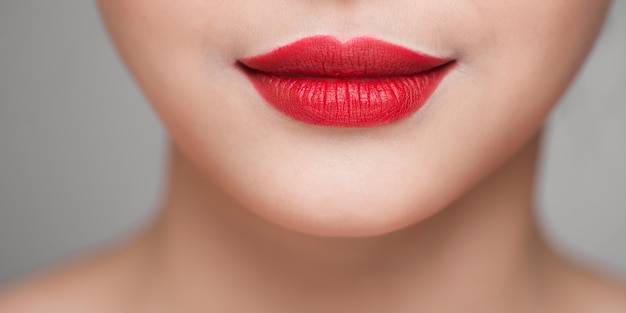 Rostro de mujer hermosa con lápiz labial rojo en labios sexy llenos regordetes