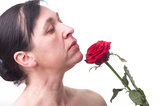 Rostro de una mujer madura con una rosa Signos de envejecimiento de la piel después de los 40