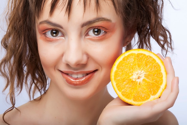 Foto rostro de mujer con naranja jugosa