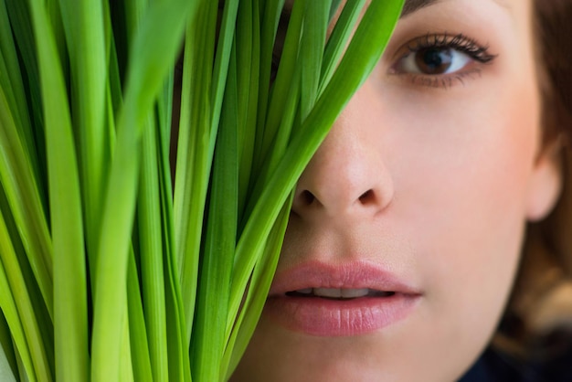 Rostro de niña cubierto de pasto verde