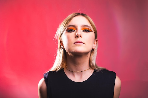 Rostro serio joven mujer caucásica en un estudio de fotografía con un fondo rojo.