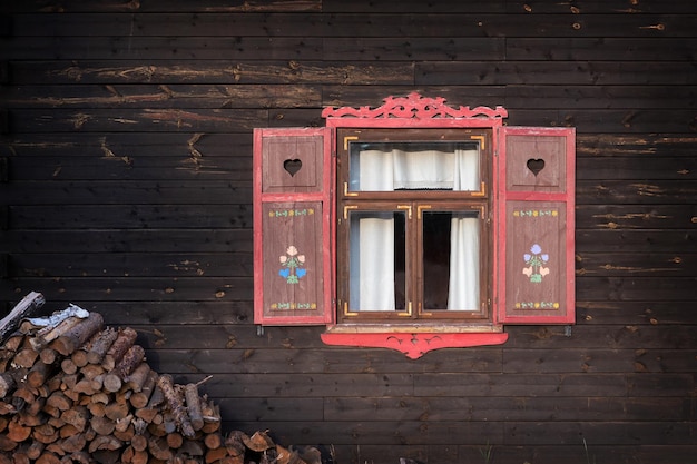 Rot geöffnete Fensterläden des alten Holzhauses