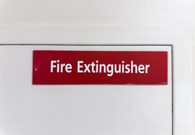 Rot-weißes Feuerlöscherschild an der Wand, das die Anwesenheit von Notfallsicherheitsgeräten anzeigt