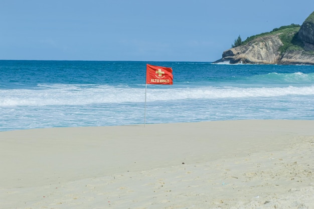 Rote aktuelle Signalflagge geschrieben hohes Risiko an einem Strand in Rio de Janeiro Brasilien