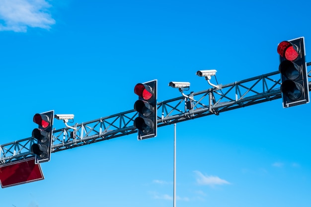 Rote Ampeln und Kameras gegen blauen Himmel