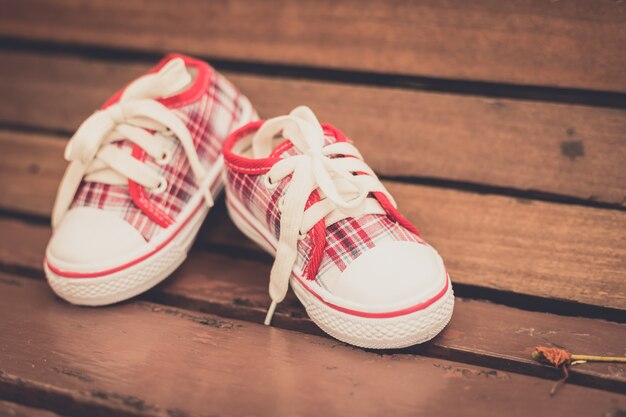 Rote Babyschuhe auf Holzstuhl