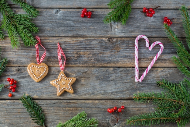 rote Beeren, Zweige aus Fichte, Zuckerstange, zwei Weihnachtsdekorationen (Herz und Stern)