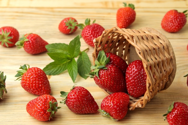Rote Beerenerdbeeren in einem Weidenkorb auf einem Naturholztisch