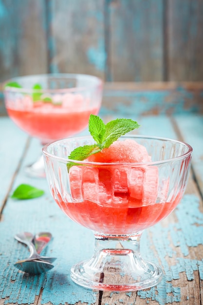 Rote Beerensorbet mit Minze in einem Glas auf Holztisch