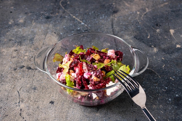 Rote-Bete-Feta-Käse-Salat in einer Glasschüssel-Gabel auf einem dunklen Foto mit blauem Hintergrund