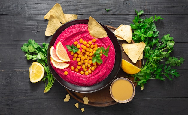 Rote-Bete-Hummus in einer Platte auf einem dunklen Hintergrund