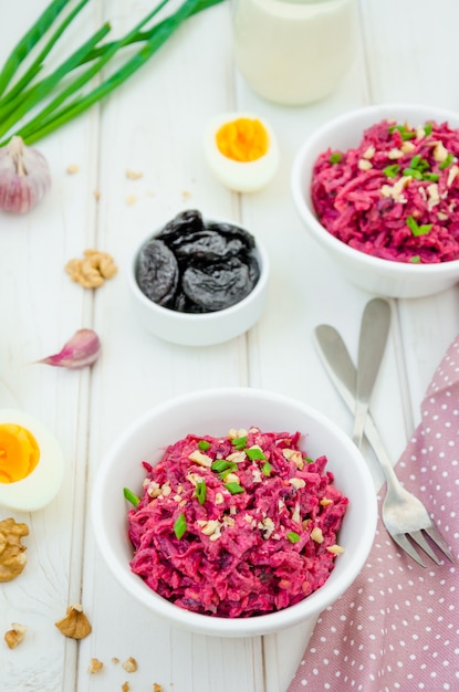 Rote-Bete-Salat mit Pflaumen, Walnüssen, Eiern und Sauerrahm in einer Schüssel