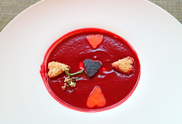 Rote-Bete-Suppe mit herzförmigem Gemüse in einem weißen Teller