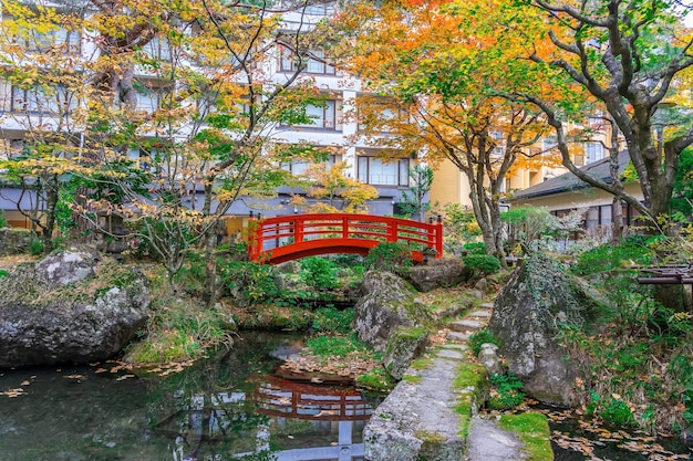 Rote Brücke im japanischen grünen Park mit Herbstfarbenblättern, japanischer Herbstfall