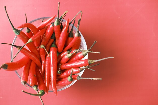 Rote Chilischote in einer Glasschüssel auf Rot