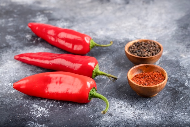 Rote Chilischoten mit aromatischen Gewürzen auf Marmor.