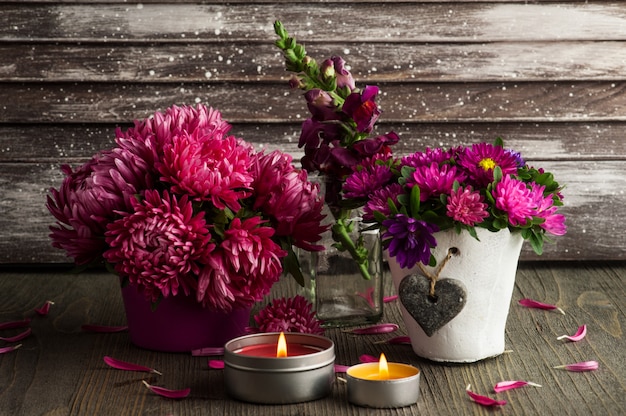 Rote Chrysanthemenblumen und brennende Kerzen