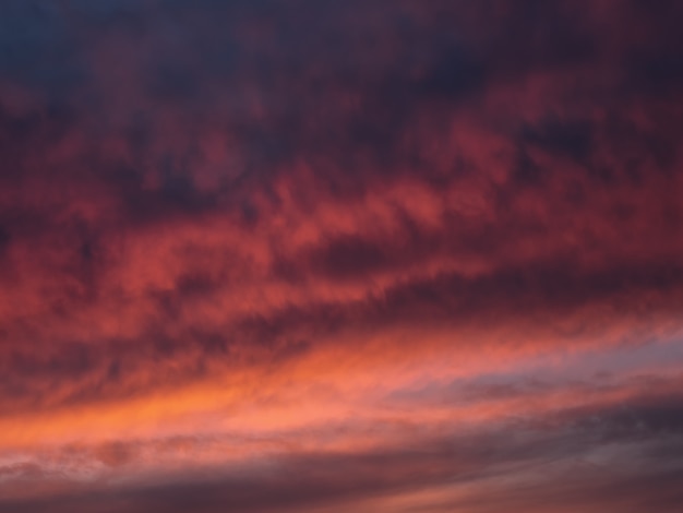 Rote dramatische abendliche Cumuluswolken am Himmel. Bunter bewölkter Himmel bei Sonnenuntergang. Himmelsbeschaffenheit, abstrakter Naturhintergrund