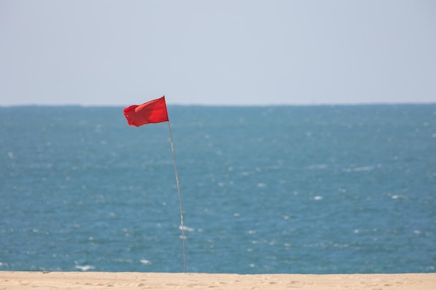 Rote Fahne am Warnschild des Meeres