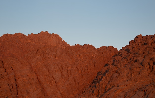 Rote felsige Berge gegen den blauen Himmel