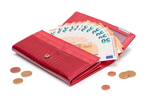 Rote Frauentasche mit Euro-Banknoten und verstreuten Euro-Cent-Münzen geöffnet