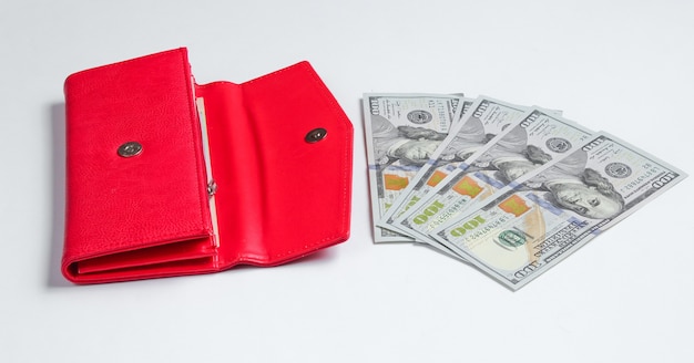 Rote Geldbörse und hundert Dollarnoten auf Weiß.