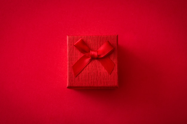 Rote Geschenkbox auf rotem Hintergrund Draufsicht