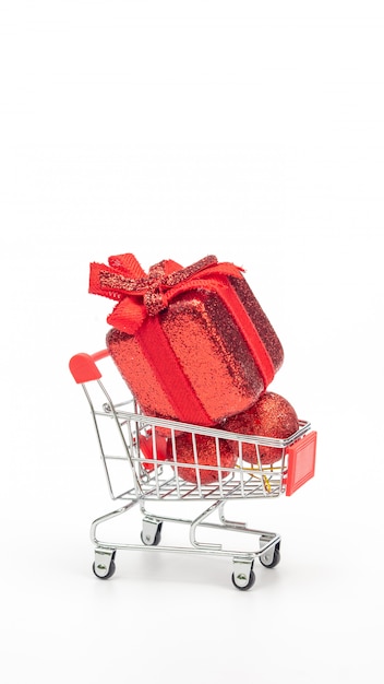 Rote Geschenkbox in einem Warenkorb auf einem weißen Hintergrund.