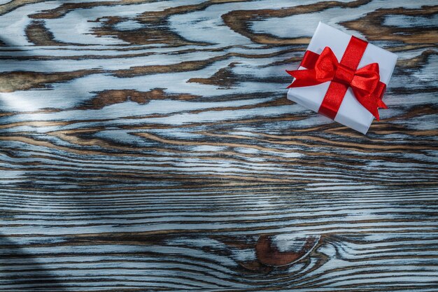 Rote Geschenkbox mit Schleife auf Holzhintergrund