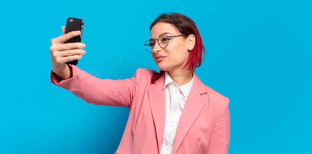 Rote Haare coole Frau mit einem Smartphone