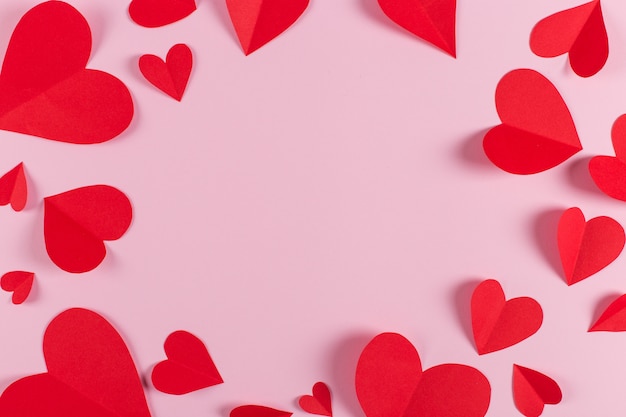 Rote Herzen sind auf rosa Hintergrund handgemacht. Vorbereitung für den Valentinstag mit einem Platz für Text. Speicherplatz kopieren.