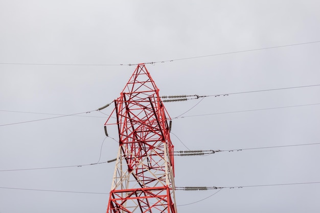 Rote Hochspannungsleitungen mit hohem Pylon, elektrischer Hochspannungs-Sendemast für die Herstellung