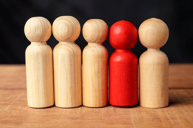 Foto rote holzfiguren zeichnen sich aus der menge an holzfiguren aus