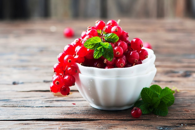 Rote Johannisbeere und Minze auf dem Holztisch