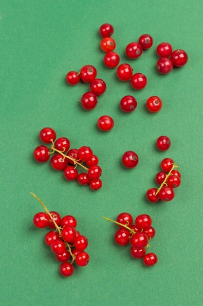 Rote Johannisbeeren auf grüner Oberfläche. Flach liegen.