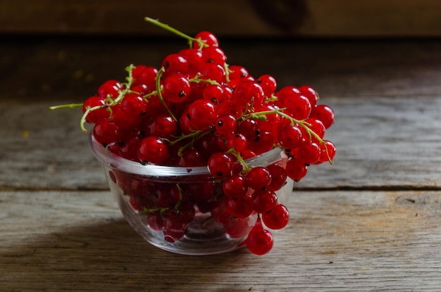 Rote Johannisbeeren in einer Glasschüssel auf einem Holztisch