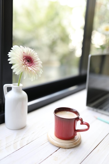 Rote Kaffeetasse und Gerbera-Blume