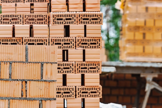 Rote Keramikziegel auf der Baustelle Keramoblock Hohlziegel Bau eines Gebäudes aus rotem Backstein Nahaufnahme Material für den Bau von Wänden und Trennwänden