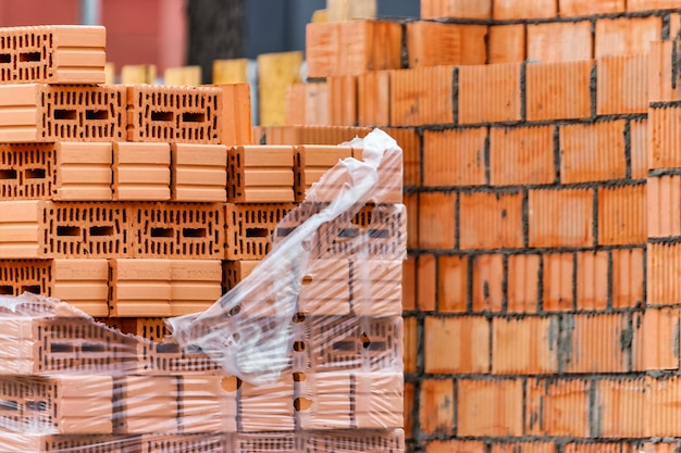 Rote Keramikziegel auf der Baustelle Keramoblock Hohlziegel Bau eines Gebäudes aus rotem Backstein Nahaufnahme Material für den Bau von Wänden und Trennwänden