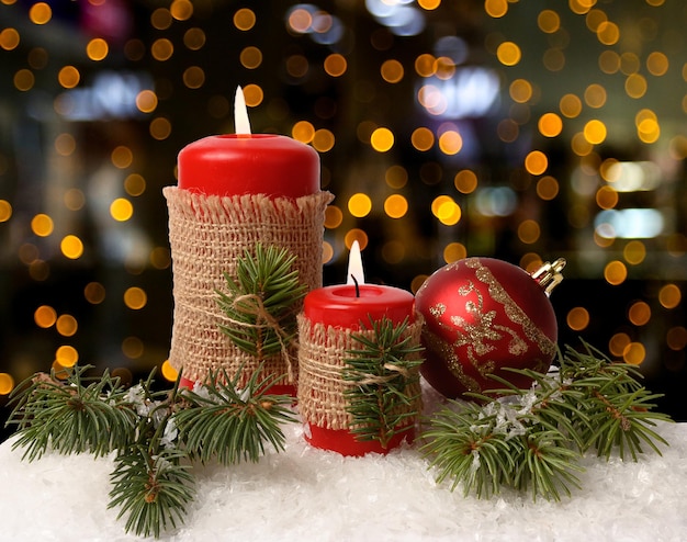 Rote Kerzen auf weißem Schnee. Boke im Hintergrund. Weihnachtsdekoration.