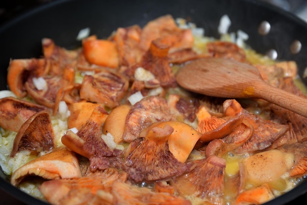 Rote Kiefernpilze in einer Pfanne braten